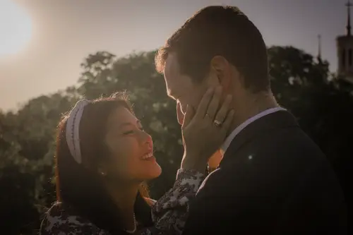 Femme enceinte en robe blanche dans un champ de fleurs.