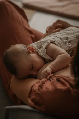Mariée en robe de dentelle, regardant pensivement par une grande fenêtre.
