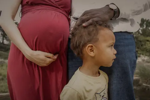 Silhouette d'une famille se tenant la main au coucher du soleil sur une plage.